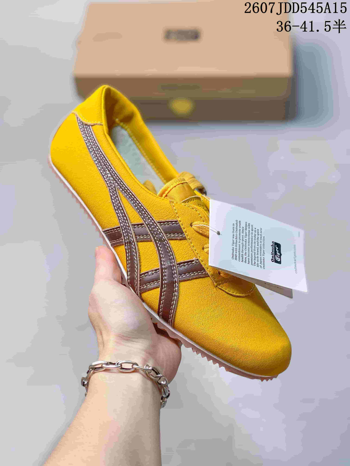 Yellow low-top sneaker with dark metallic side stripes and matching yellow laces.