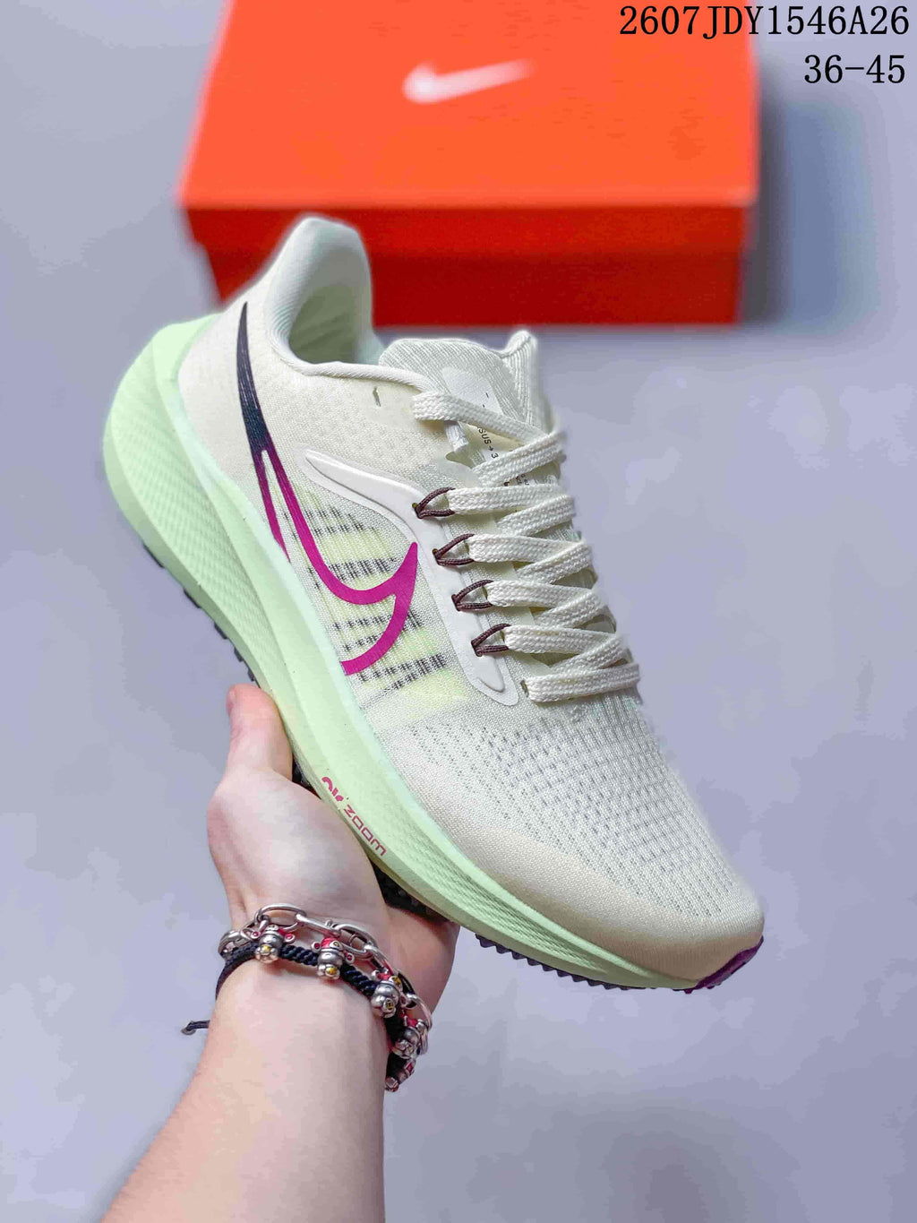 Light green and white Nike Air Zoom Pegasus 39 sneaker with magenta side branding and a pale green midsole.