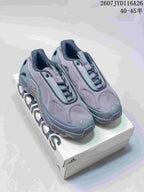 Pair of gray adidas low-top sneakers displayed on an adidas shoe box, with the model code and size range shown at the top.
