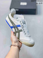 White Onitsuka Tiger slip-on sneaker with olive and blue side stripes and a cream-colored outsole.