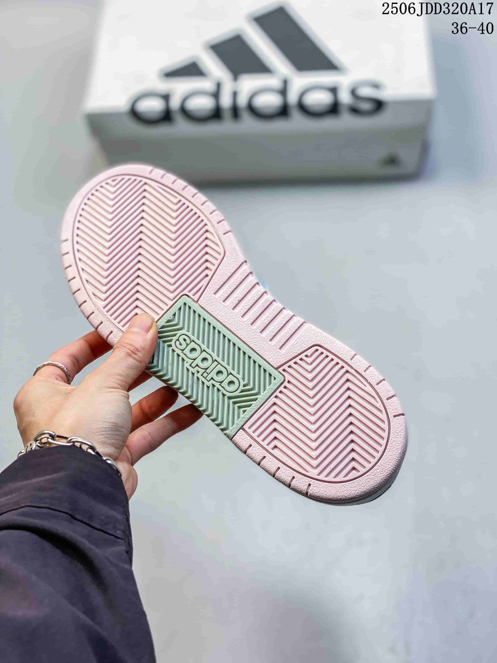 Bottom view of the adidas sneaker showing a pink and pale green textured outsole with herringbone-style tread.