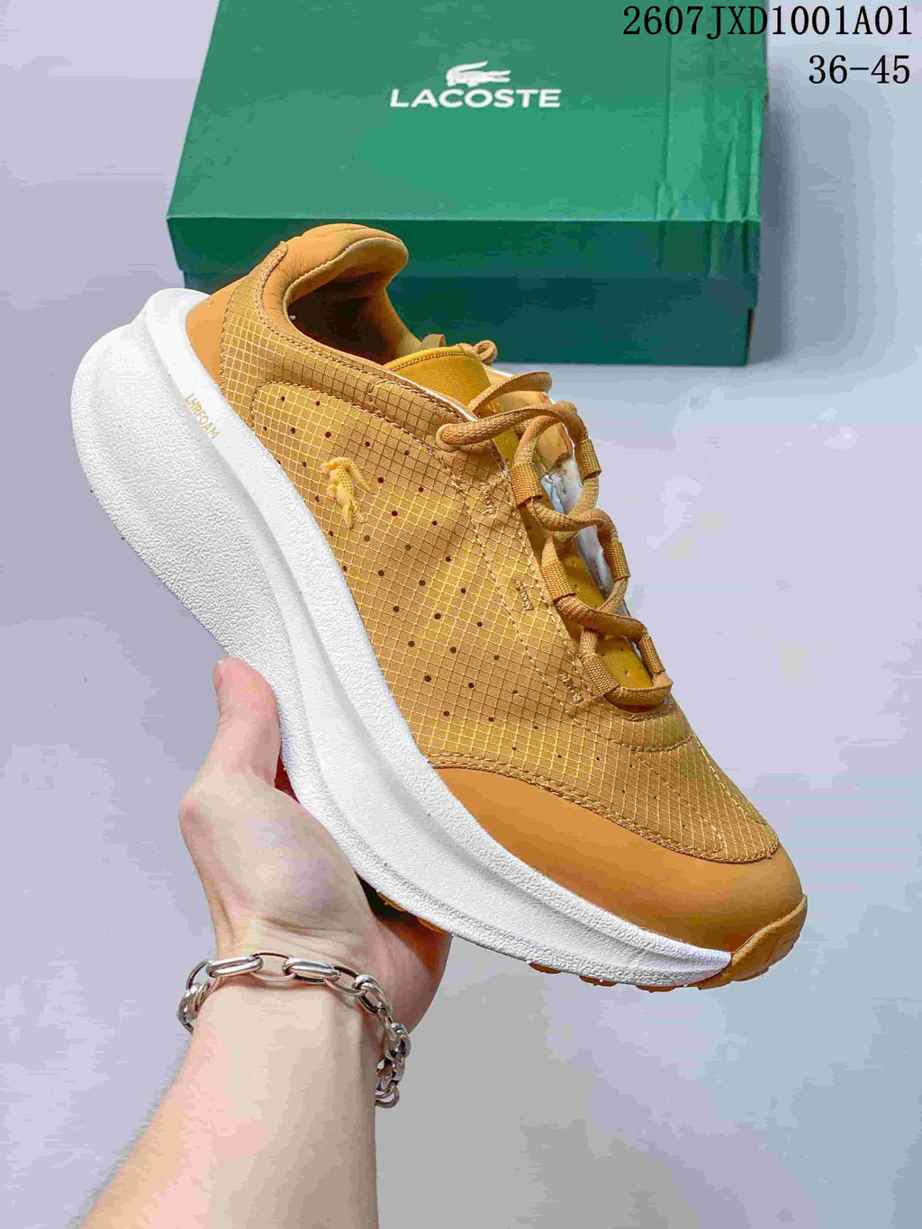 Tan Lacoste lace-up sneaker with white sole and green shoebox