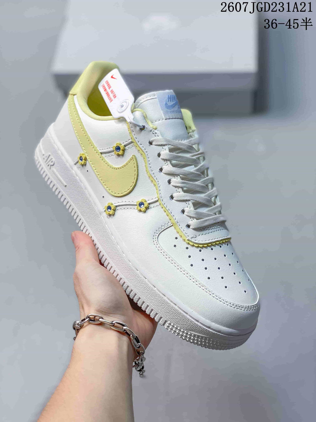 Angled side view highlighting the white and pale yellow color scheme, Swoosh and flower-shaped side decorations.