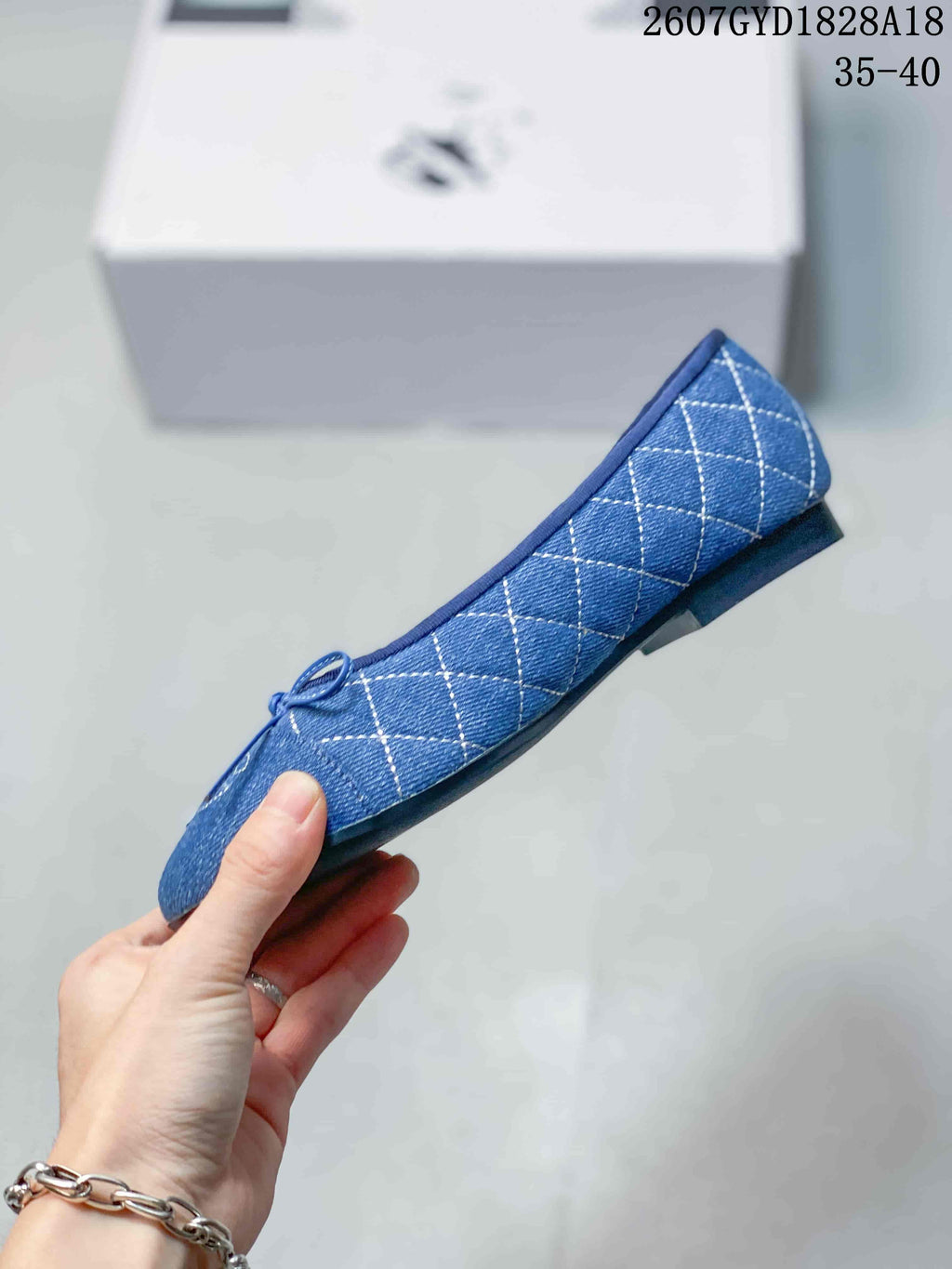 Side profile of the blue ballet flat showing the low silhouette, quilted upper, bow, and short heel.