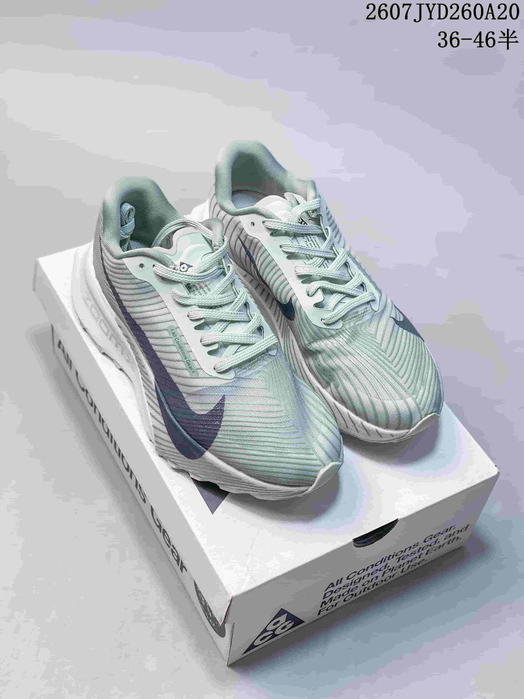 Pair of pale green and white Nike ACG Ultrafly Trail sneakers with navy accents displayed on an ACG shoebox; image text shows 2607JYD260A20 and 36–46 half sizes.