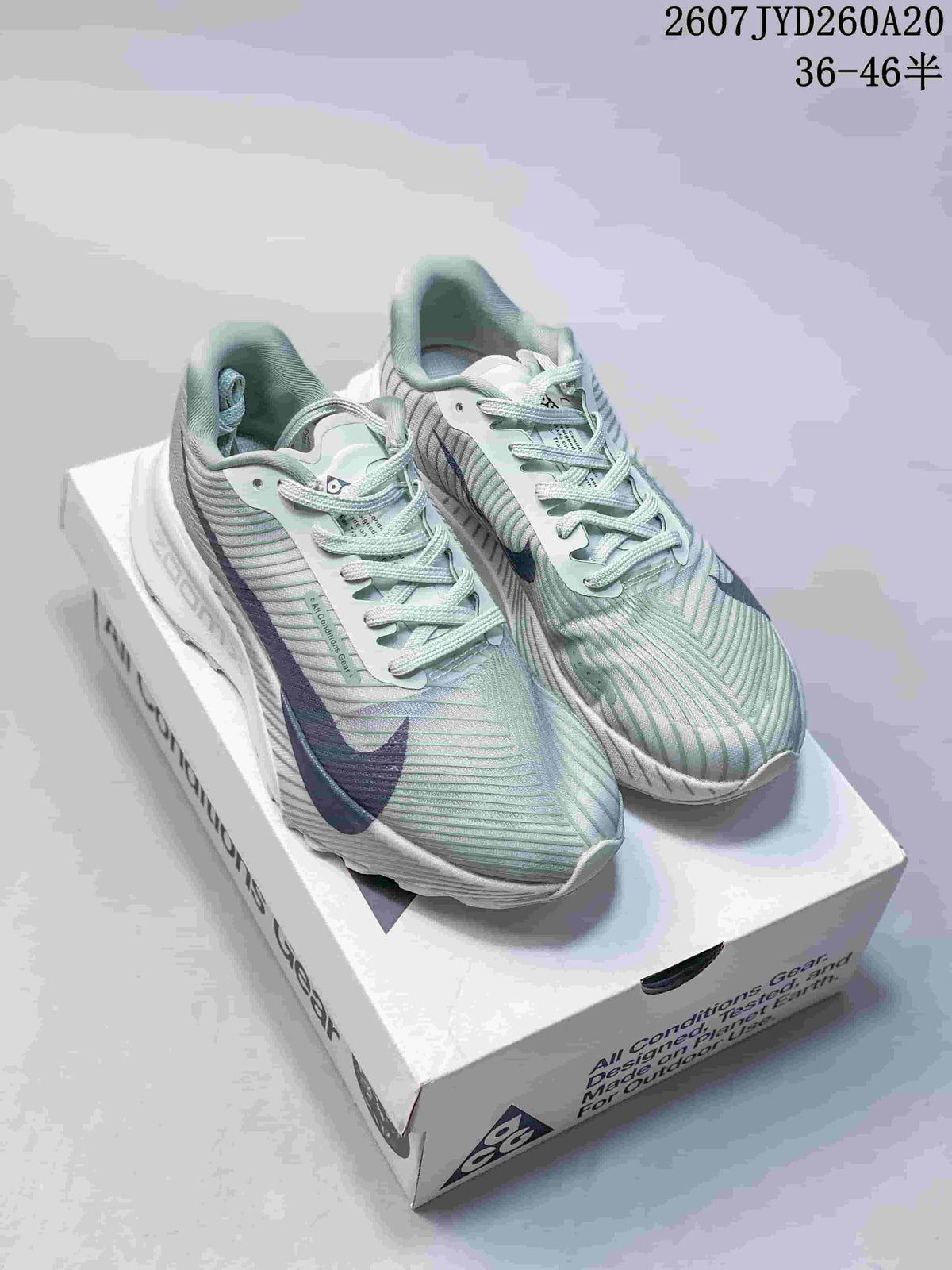Pair of pale green and white Nike ACG Ultrafly Trail sneakers with navy accents displayed on an ACG shoebox; image text shows 2607JYD260A20 and 36–46 half sizes.
