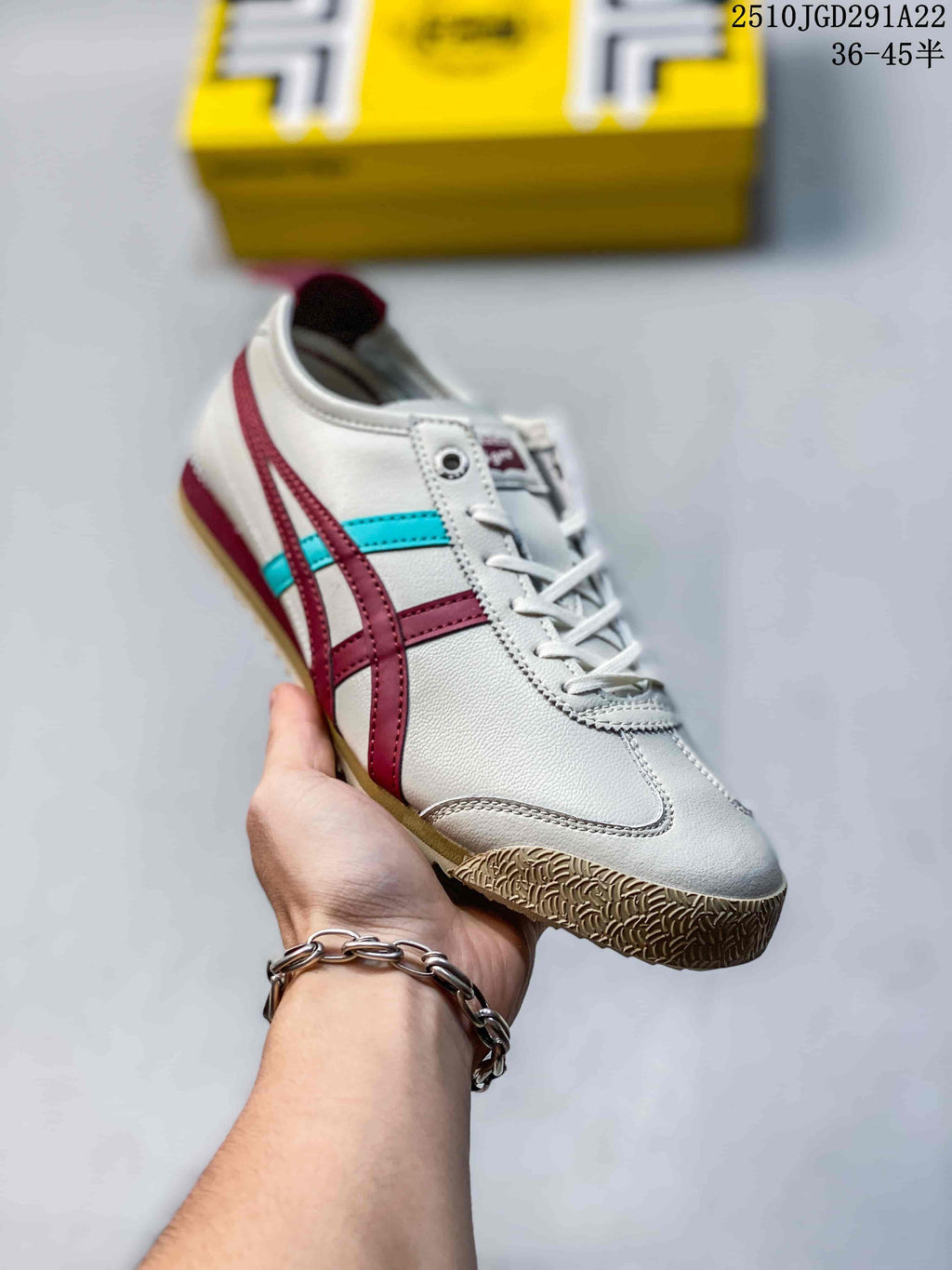 Angled side view of a white Onitsuka Tiger sneaker with burgundy and turquoise stripes and a textured gum-colored toe outsole.