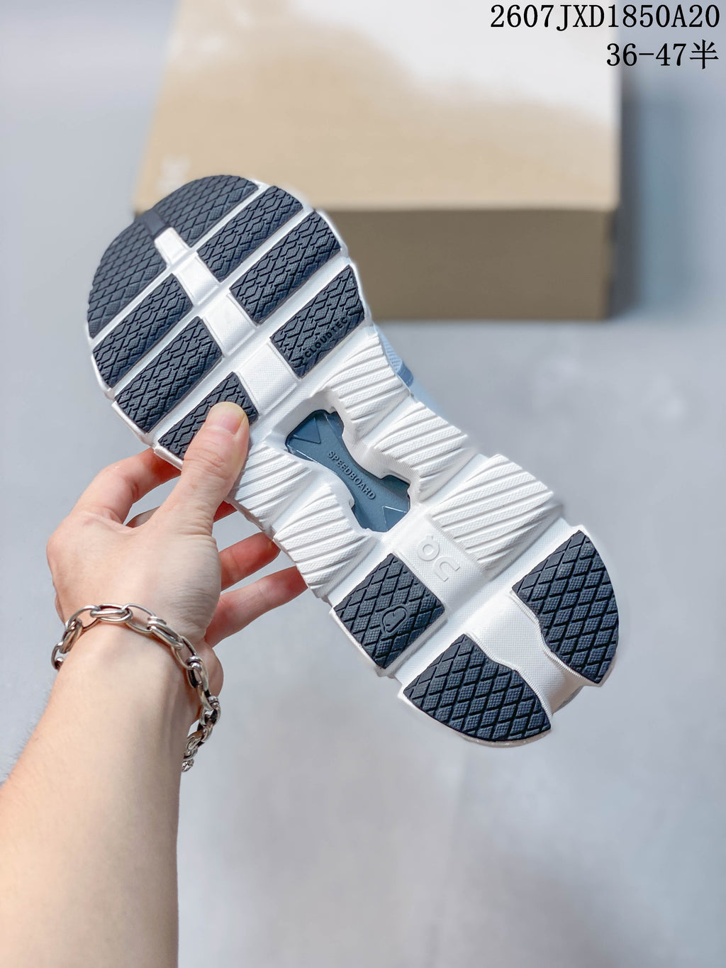 Underside of the sneaker showing a segmented white outsole with dark traction sections and CloudTec branding.