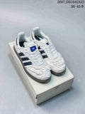 White ruched adidas Samba OG sneakers with dark contrast stripes displayed on a shoebox.