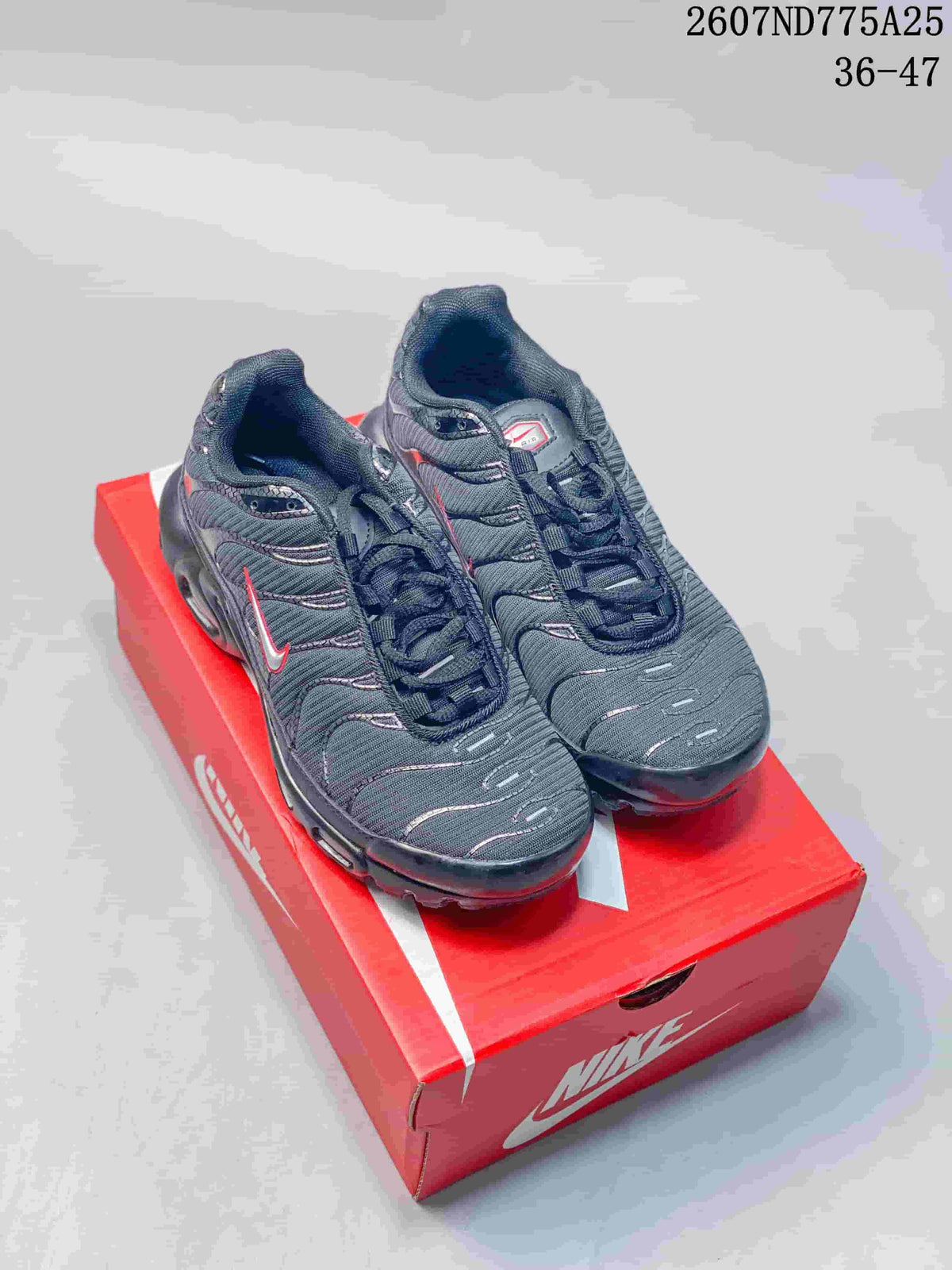 Pair of black Nike Air Max Plus TN sneakers with red and silver accents displayed on a red Nike shoebox; overlay text shows code 2607ND775A25 and size range 36–47.