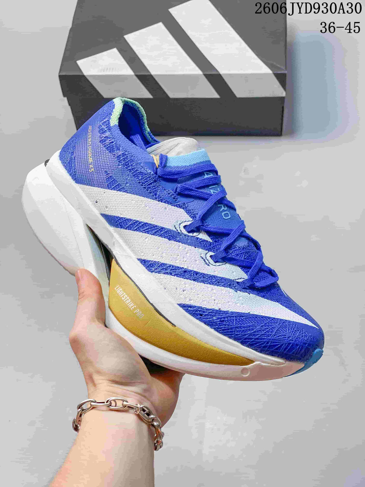 Blue and white adidas Adizero Prime X3 shoe with a gold-toned sole accent.