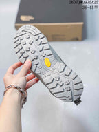 Close-up of the gray sneaker outsole showing a Vibram logo and deep lugged traction pattern.