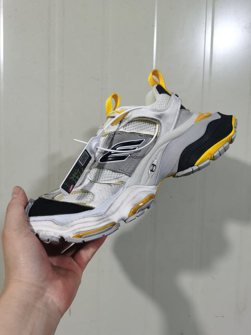 Side and top view showing the sneaker's mesh-look sections, grey overlays, yellow details, and black outsole areas.