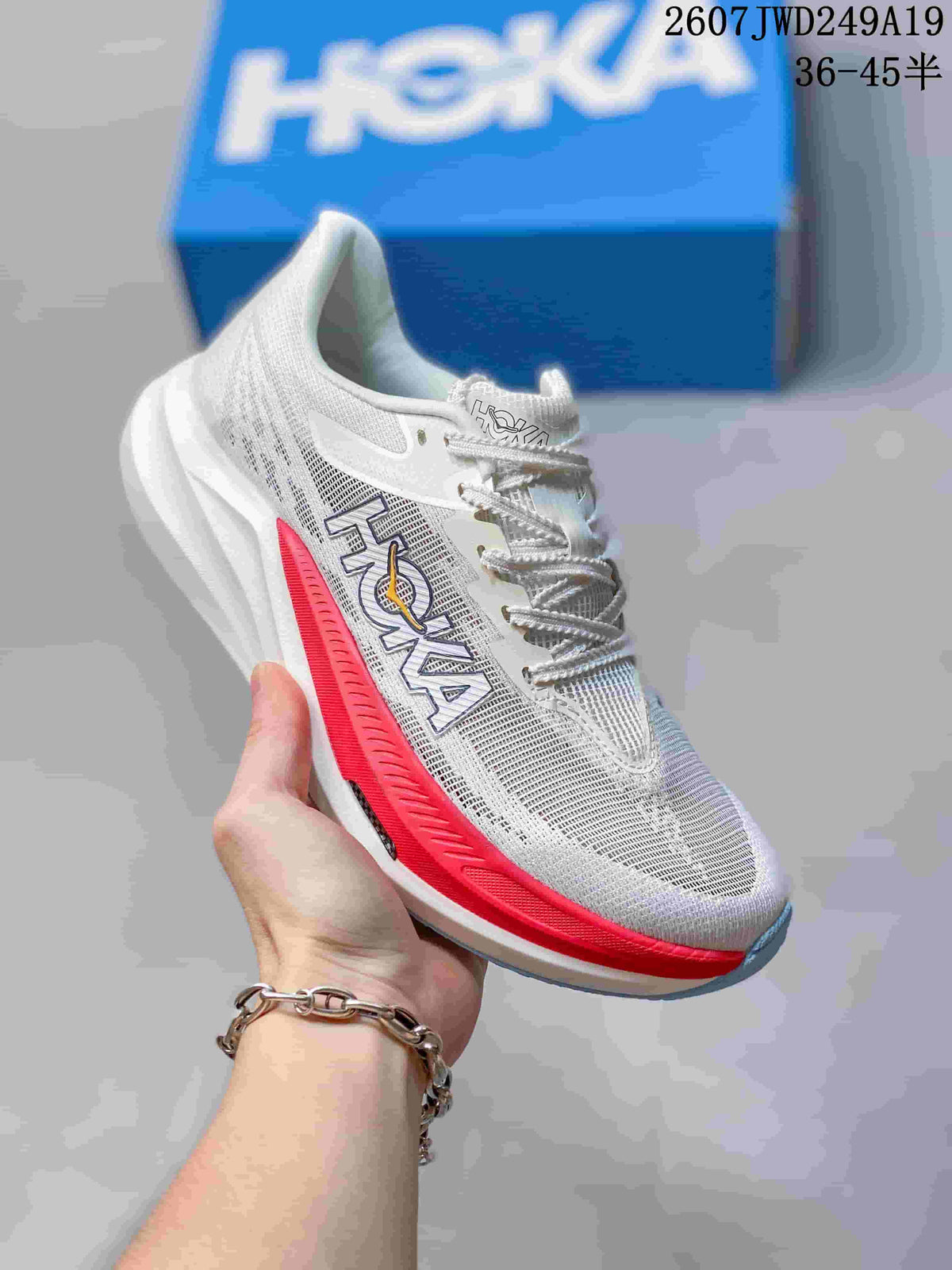 White Hoka One One MAFATE X shoe with red side and sole accents, shown against a blue shoe box.