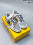 Pair of white and gray low-top sneakers with black and yellow side accents