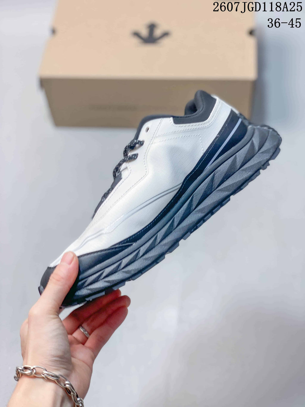 Side view showing the white upper, black accents and rugged layered sole.