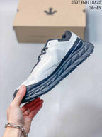 Side view showing the white upper, black accents and rugged layered sole.