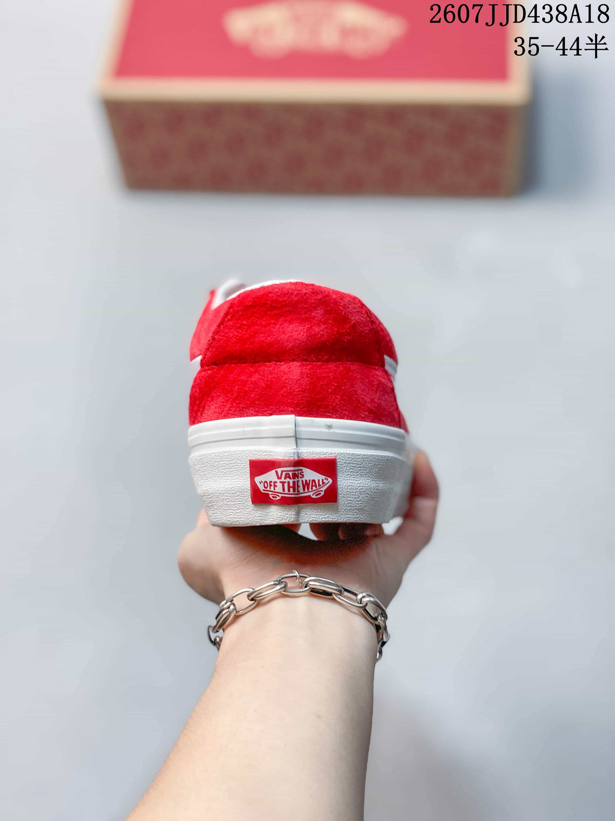 Rear view of the red sneaker with a white heel stripe and branded heel tab.