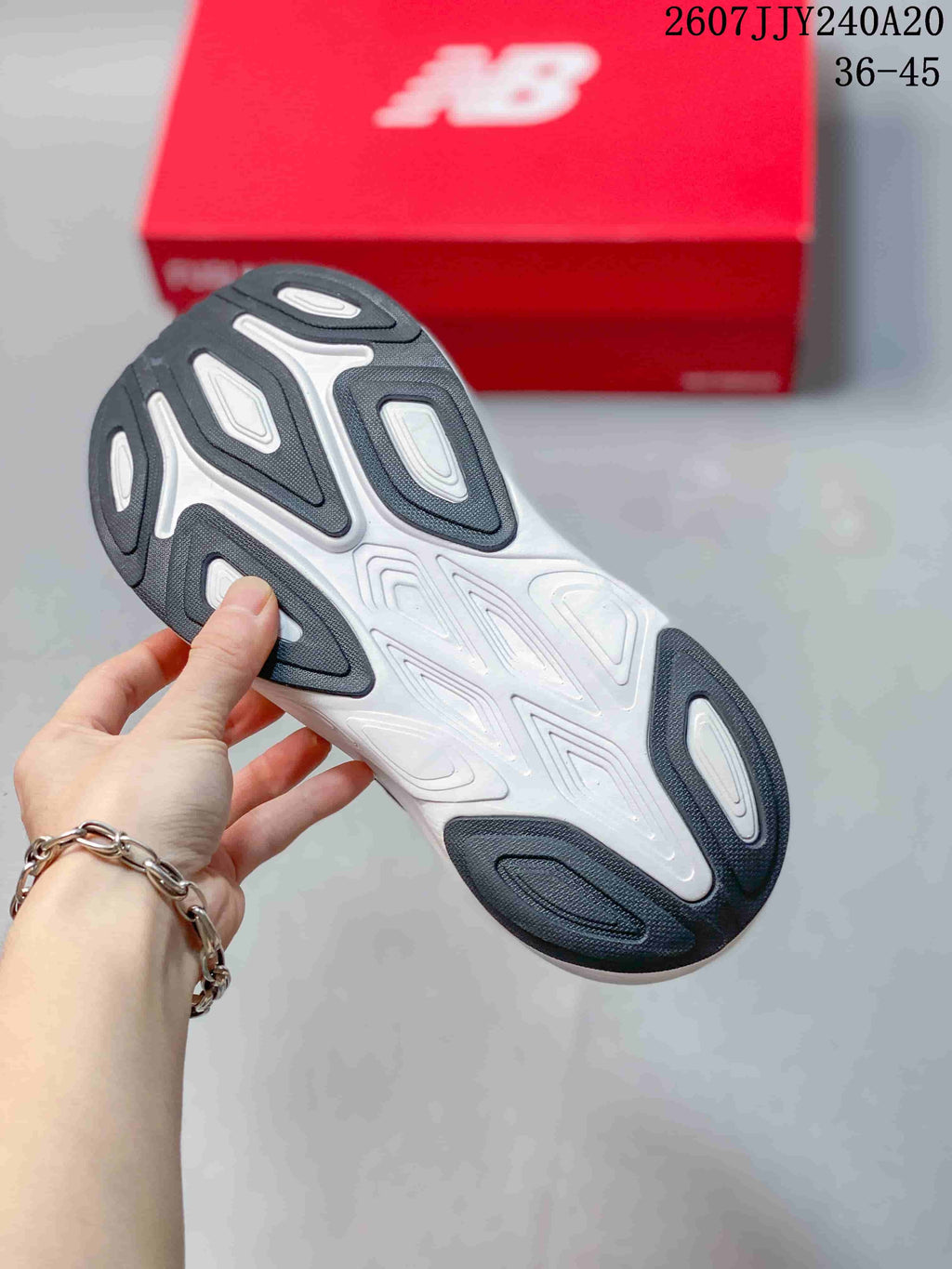 Bottom view of the shoe showing the white and dark patterned outsole with multiple traction sections.