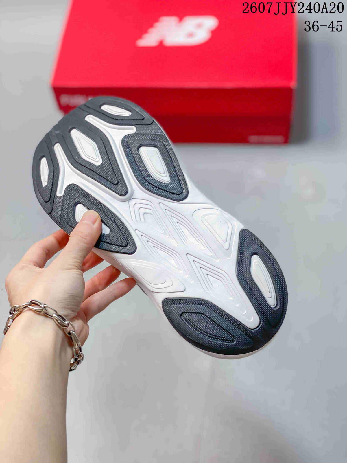 Bottom view of the shoe showing the white and dark patterned outsole with multiple traction sections.