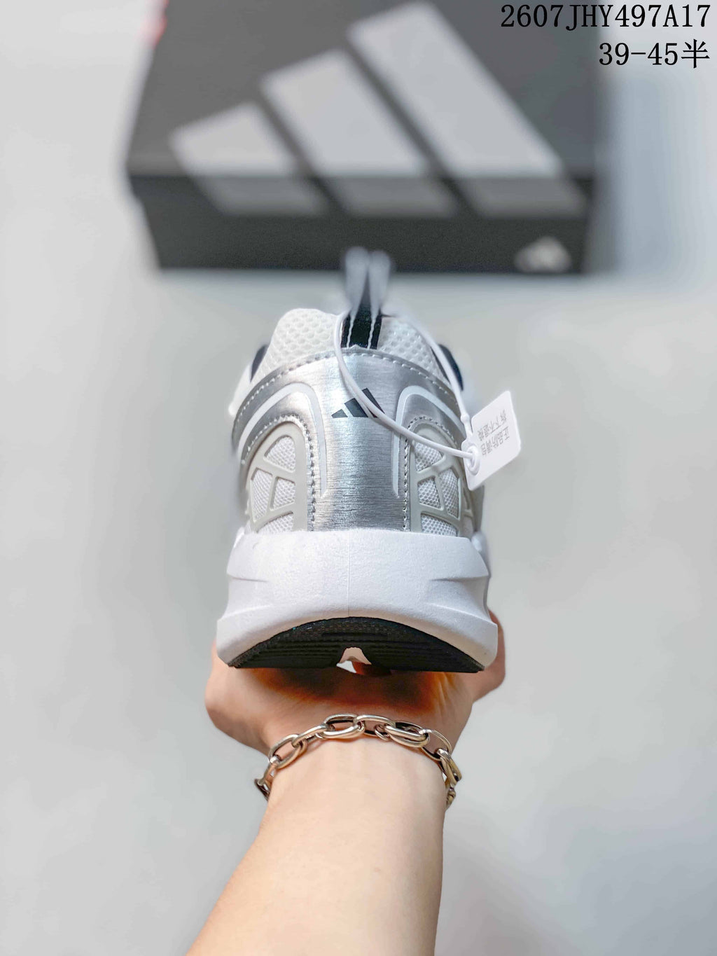 Rear view of the white sneaker showing the padded heel, pull tab and layered heel panels; image text shows style code 2607JHY497A17 and size range 39–45.