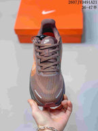 Front view of the brown lace-up sneaker showing the textured upper and reflective toe details.