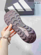 Close-up of the patterned outsole on a mauve trail running shoe