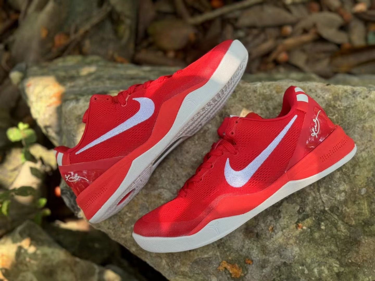 Angled view of a pair of red Nike Kobe 8 shoes with white side logos