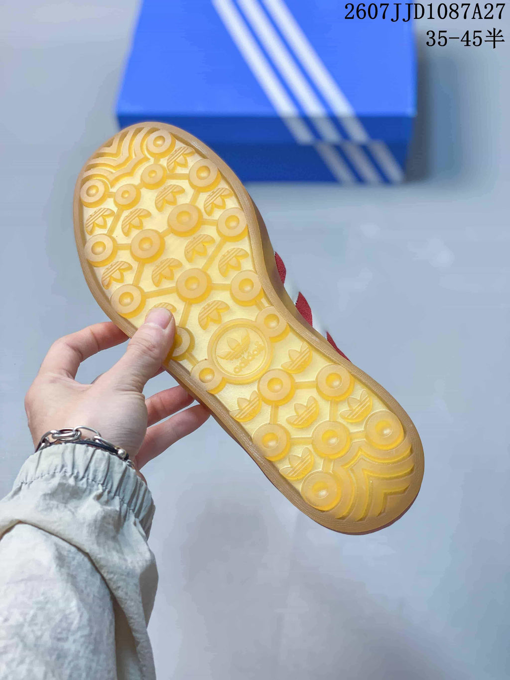 Close view of the gum-colored outsole with circular and trefoil-patterned tread.