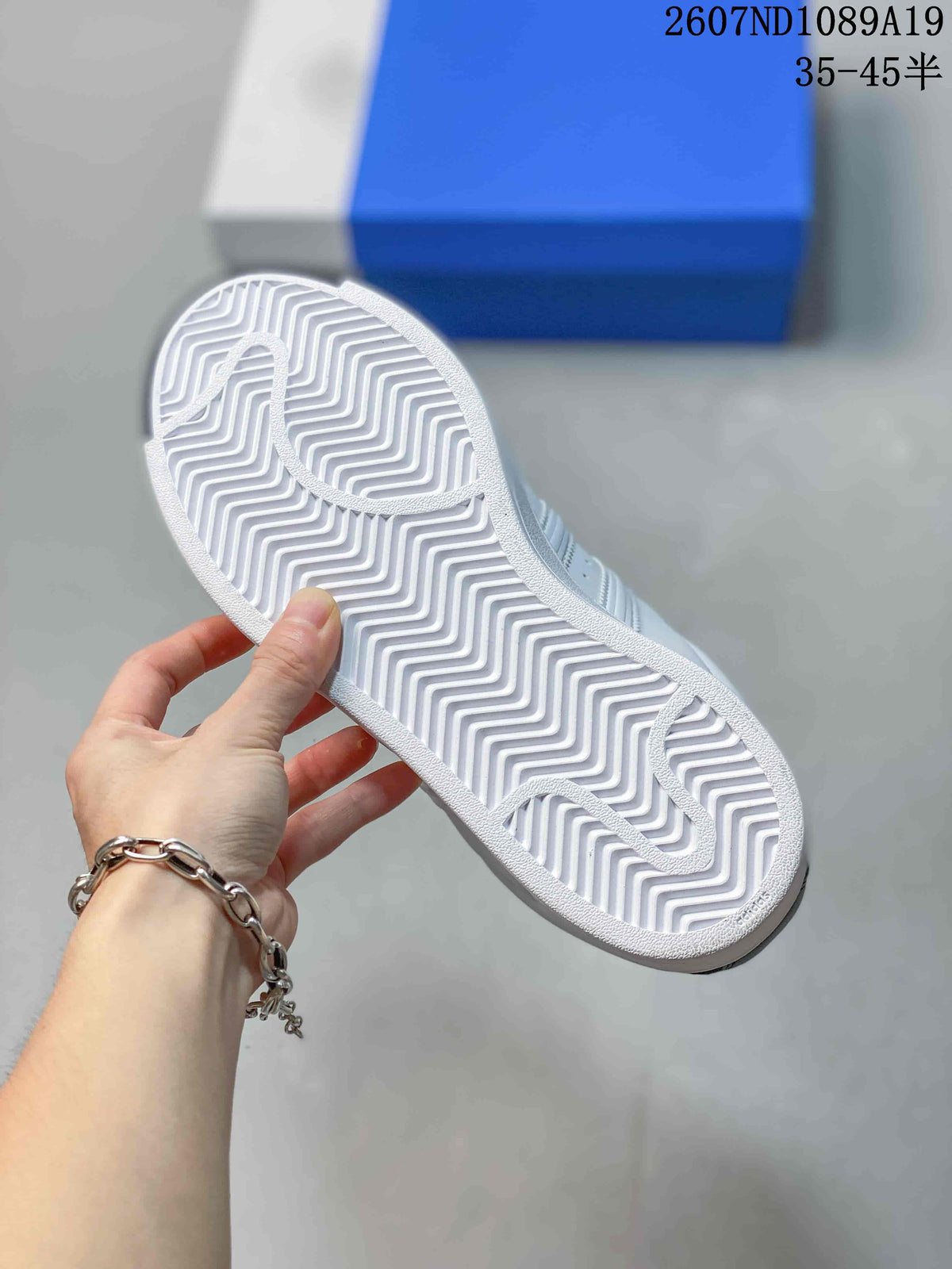 Underside of the sneaker showing a white rubber outsole with a zigzag tread pattern.