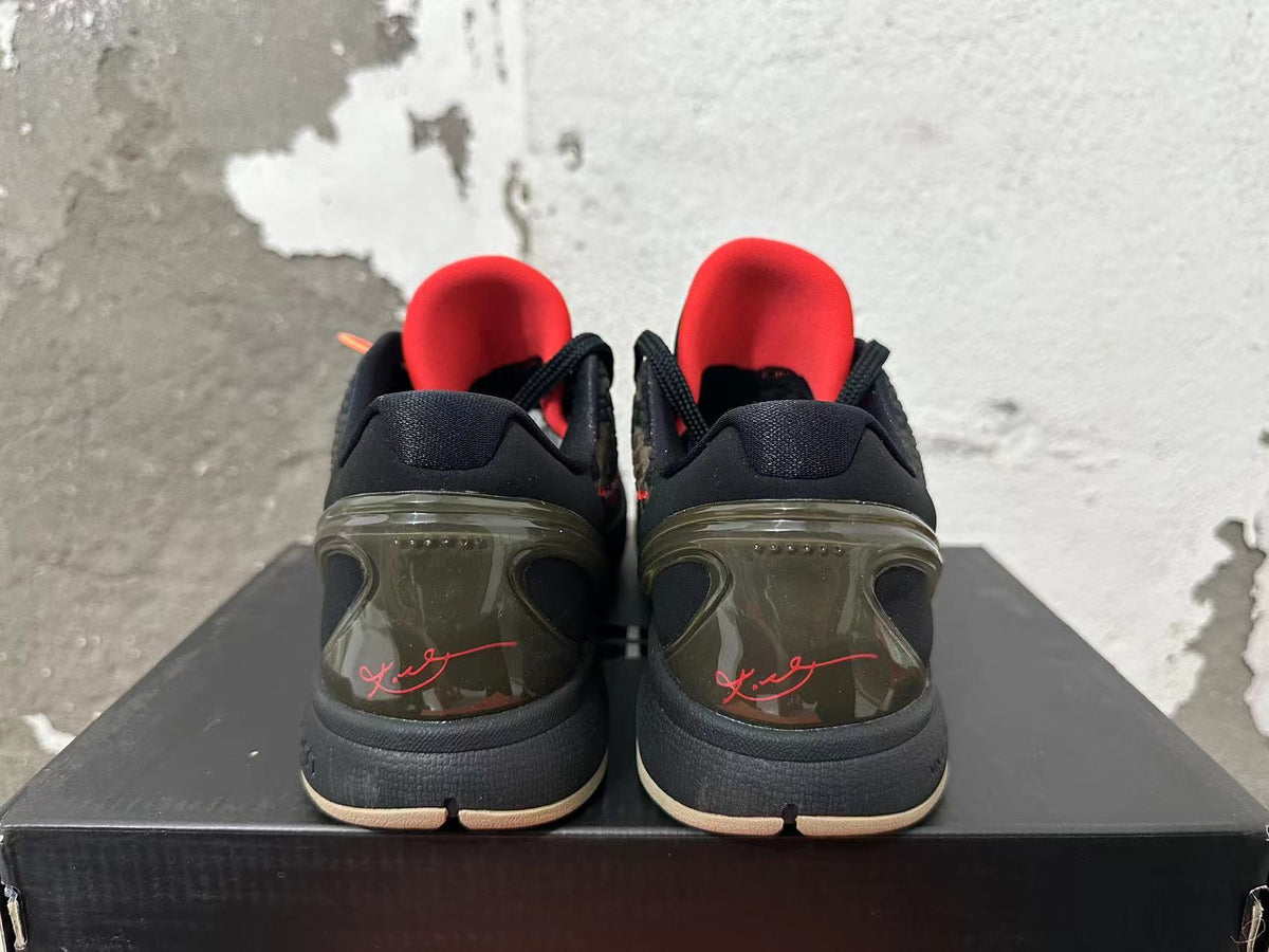Rear view of black and camouflage Nike Kobe basketball shoes with red lining and signature heel details