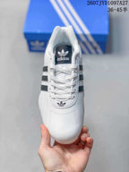 Top view showing the white laces, dark tongue label, and Trefoil logo on the toe area.