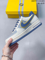 Side view highlighting the blue Swoosh, yellow trim, and white upper.