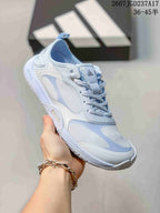 Angled side view of the crystal blue adidas sneaker showing the layered panels, laces and textured outsole.