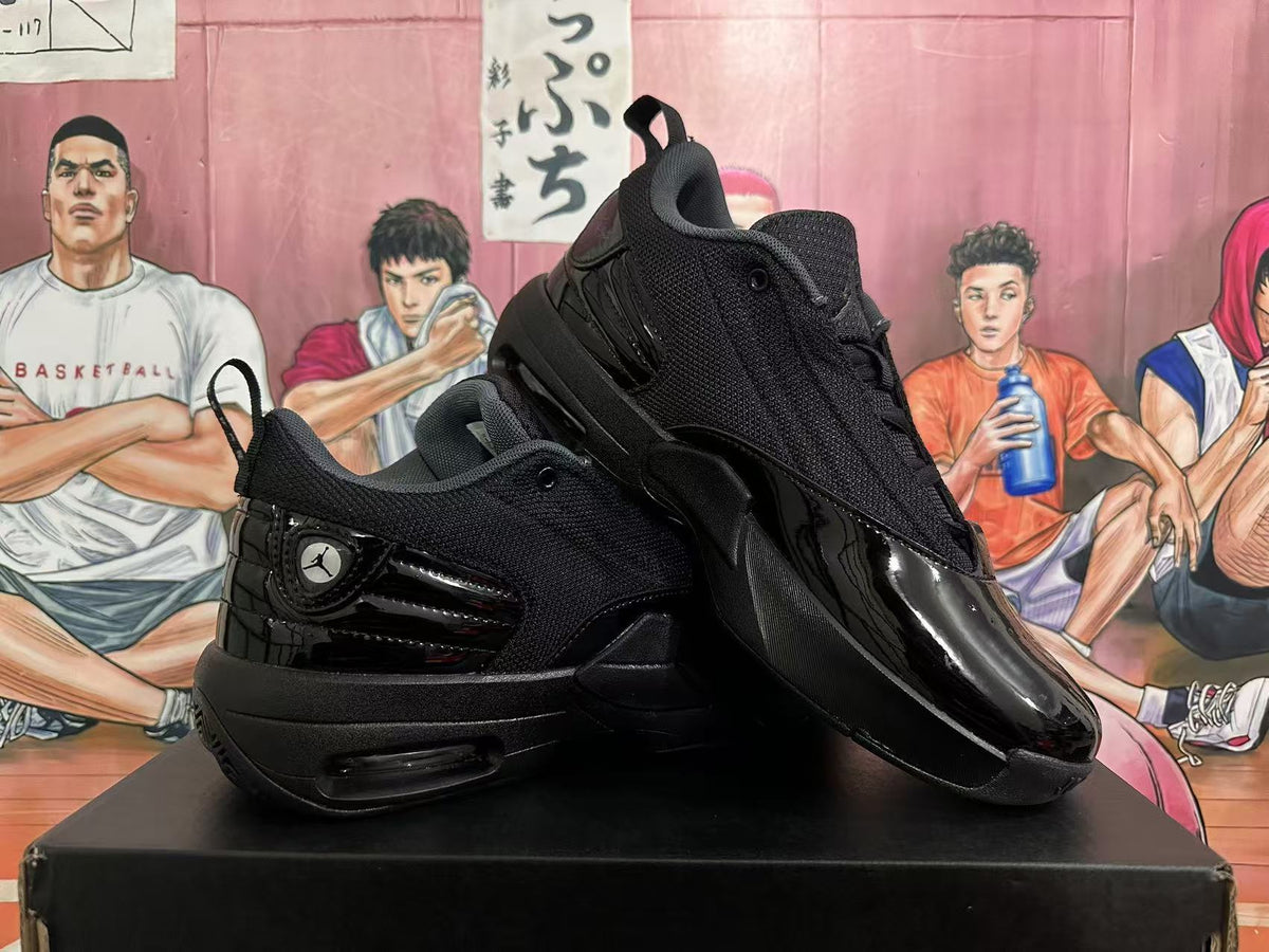 Angled view of two black Jordan sneakers displaying the textured upper, glossy overlays, pull tabs, and layered outsole.