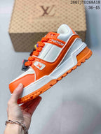 Side view showing the white and orange upper, orange laces, layered panels and textured outsole.