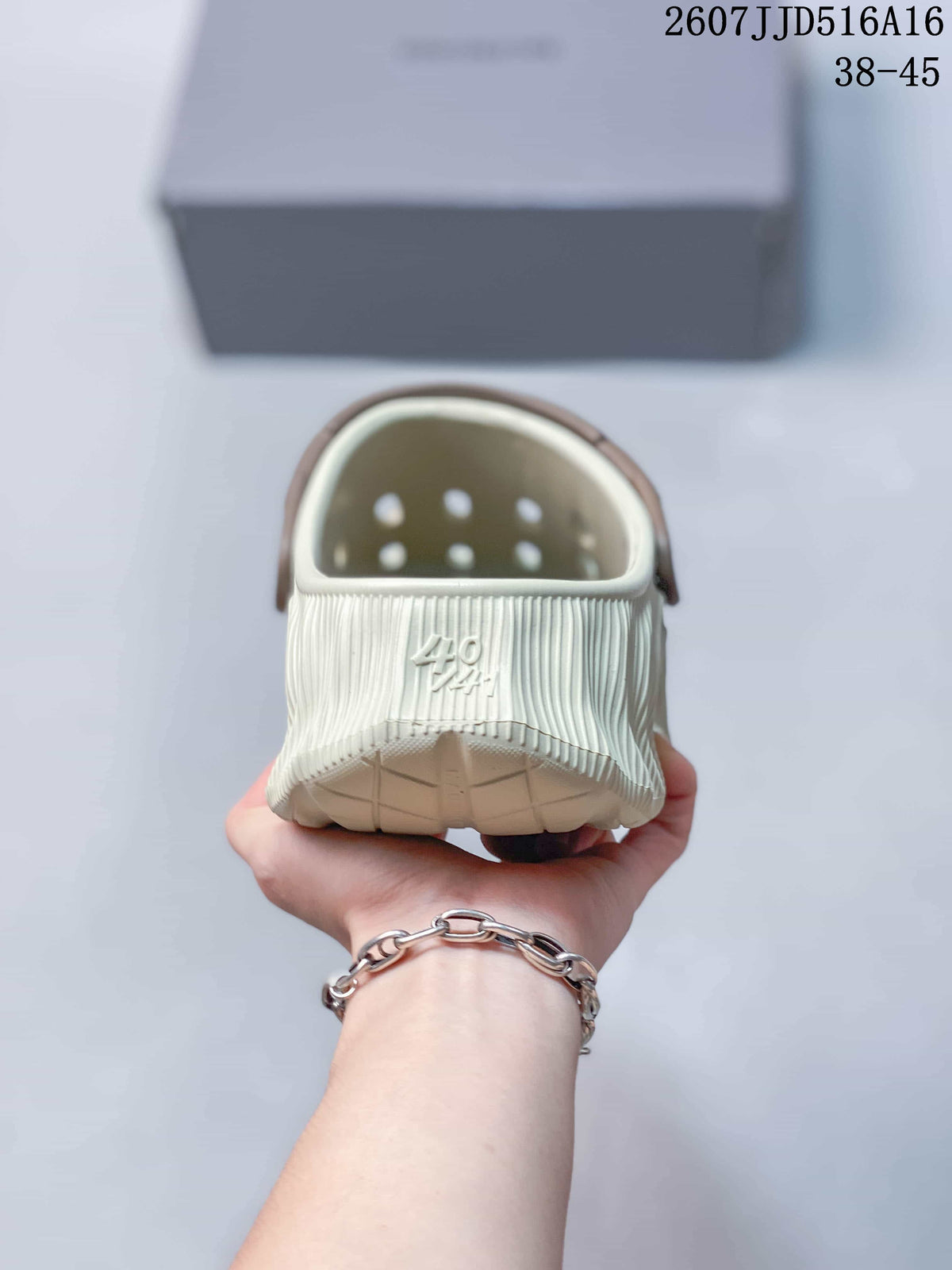 Rear view of a cream clog slide showing the covered heel opening, brown strap, ventilation holes, and visible size marking 40.