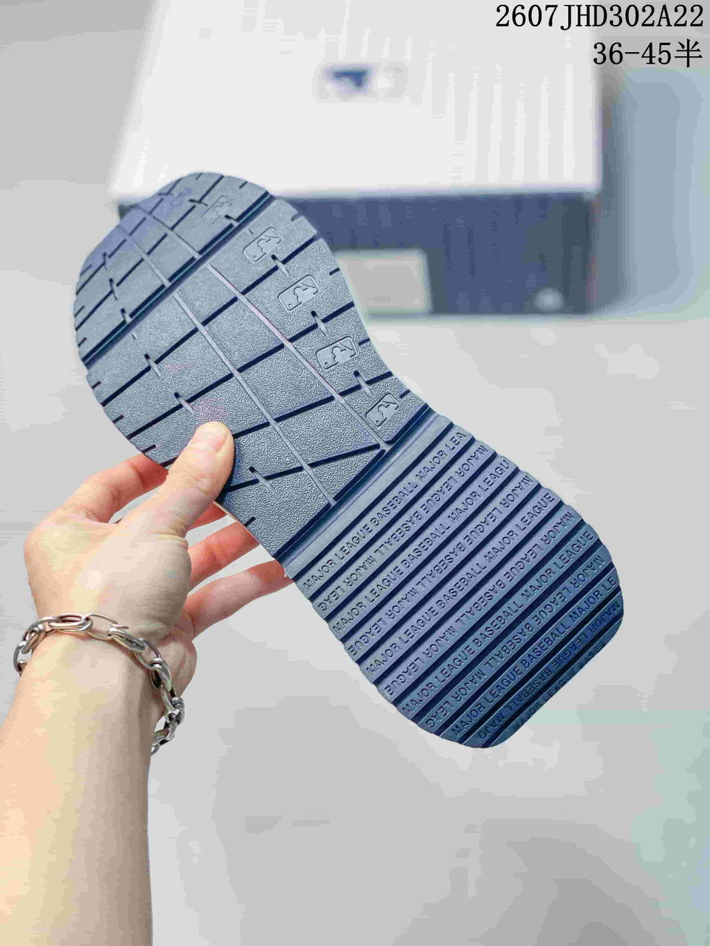 Close-up of the sneaker outsole showing its segmented tread pattern and printed MLB-related text.