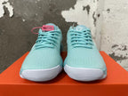 Front view of mint green Nike sneakers with lace-up closures and white ridged toe soles