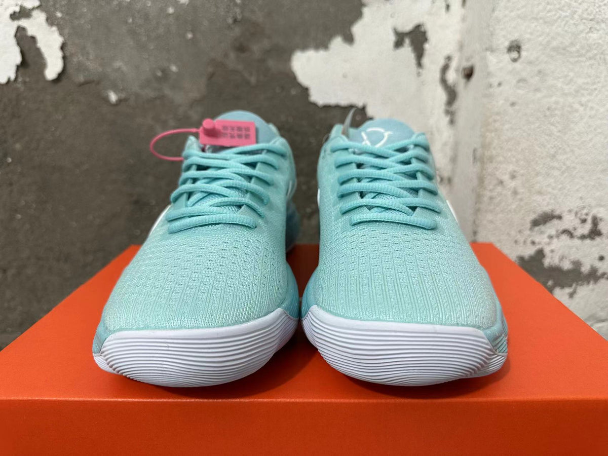 Front view of mint green Nike sneakers with lace-up closures and white ridged toe soles