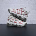 Pair of white Nike Air More Uptempo sneakers with cherry graphics and pink-trimmed lettering