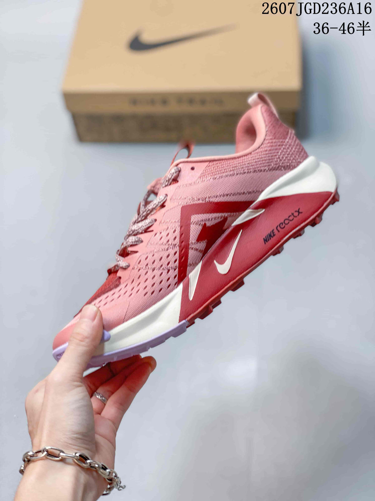 Side profile of the pink trail shoe showing the Nike Swoosh, layered upper and lugged outsole.