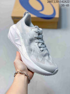 Angled side view of the light white and gray running shoe showing the textured upper, padded collar, sculpted midsole, and outsole.