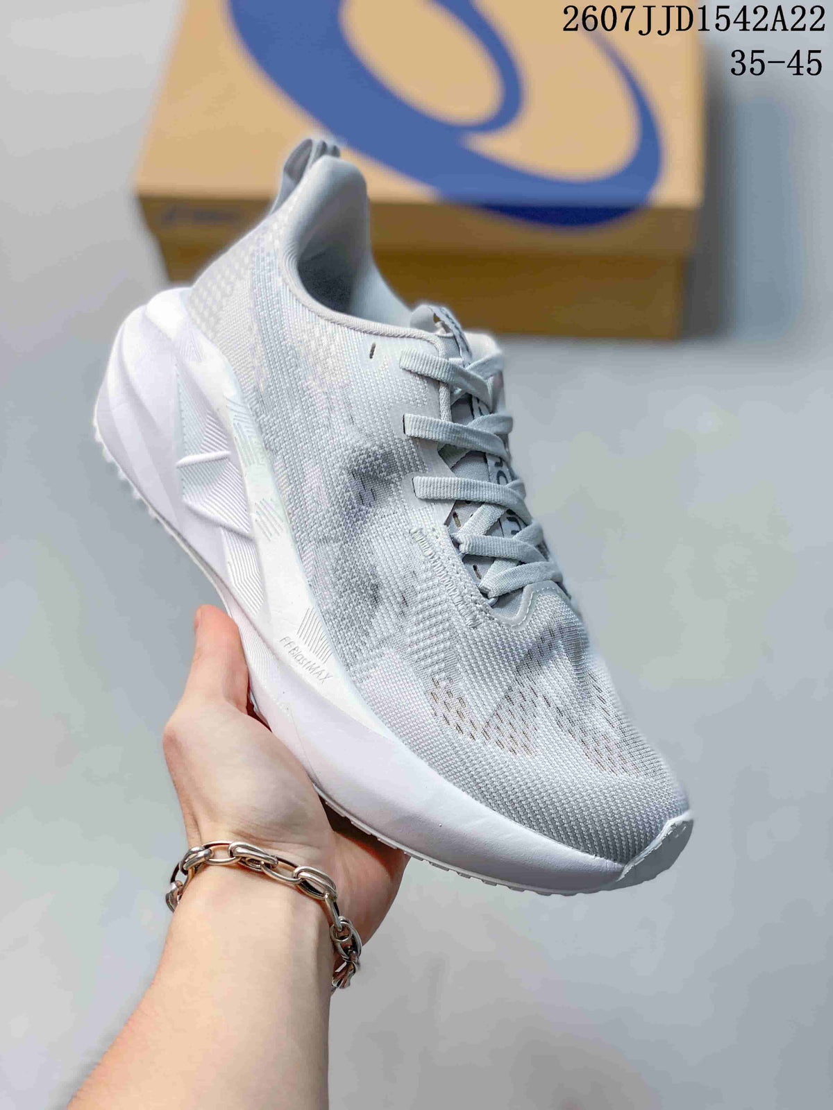Angled side view of the light white and gray running shoe showing the textured upper, padded collar, sculpted midsole, and outsole.