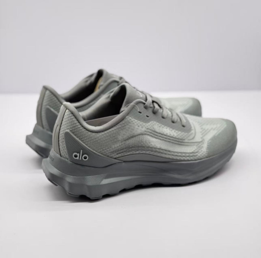 Rear three-quarter view of the gray sneakers showing the heel panels, side logo, and thick outsole.