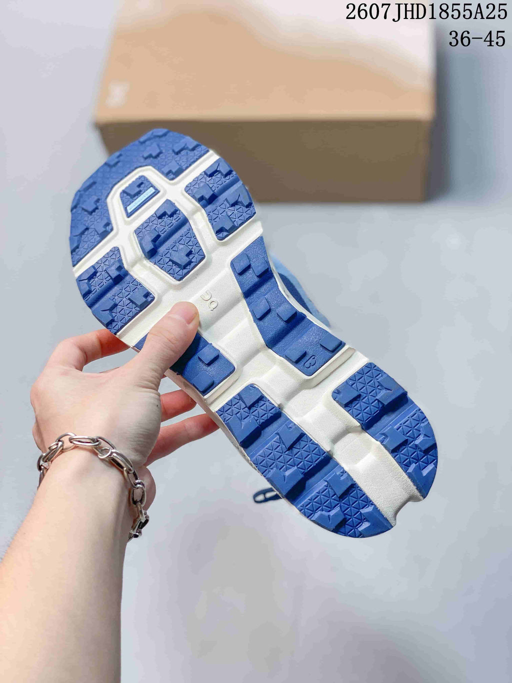 Close-up of the blue and white outsole showing deep lugged tread blocks and textured traction surfaces.