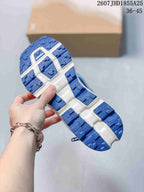 Close-up of the blue and white outsole showing deep lugged tread blocks and textured traction surfaces.