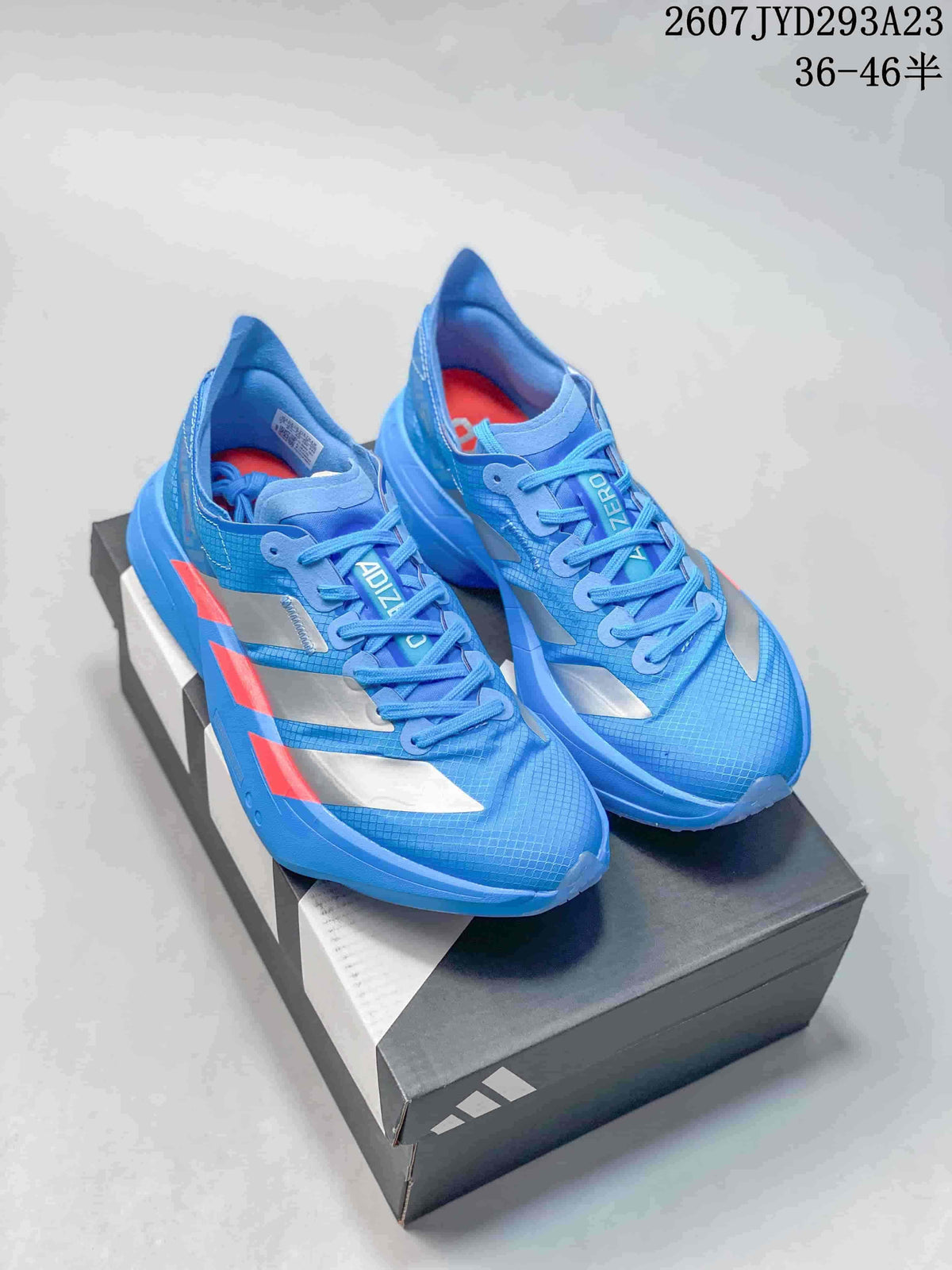 Pair of blue Adidas Ultrabounce sneakers with silver panels and red accents displayed on a shoebox; image text shows style code 2607JYD293A23 and sizes 36–46.