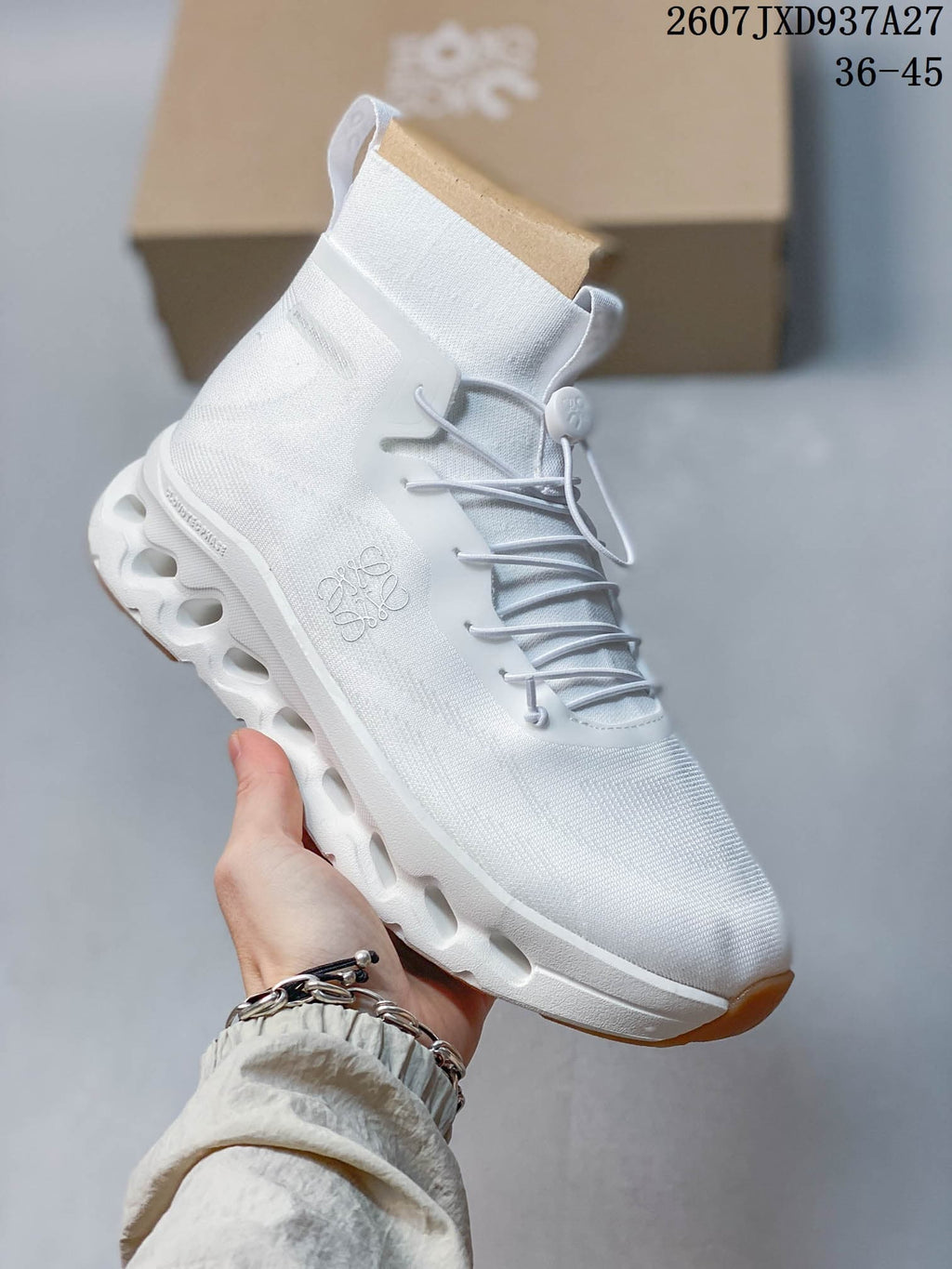 Angled side view of the white Loewe x On Cloudtilt high-top sneaker showing the textured upper, pull tab, side branding, and segmented sole.