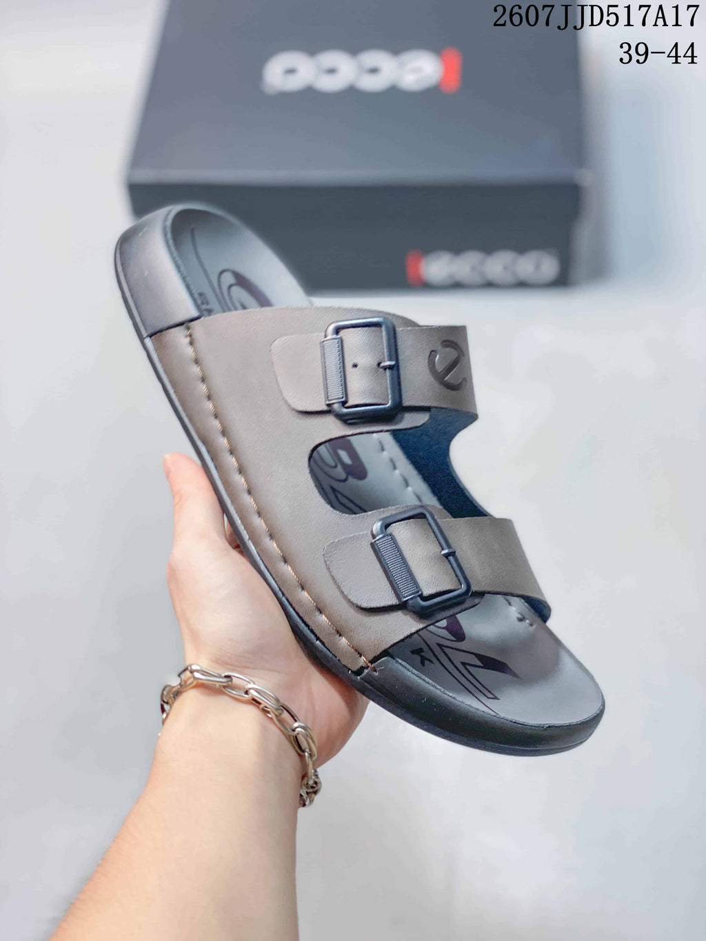 Angled view of the taupe-gray ECCO sandal highlighting its two buckle straps, open toe and dark outsole.